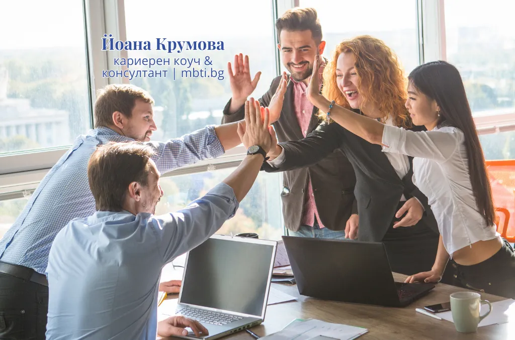 Разнообразна група от колеги, които си дават пет около маса в светъл офис, демонстрирайки екипна работа, принадлежност и сътрудничество, без стремеж към одобрение и външна валидация.